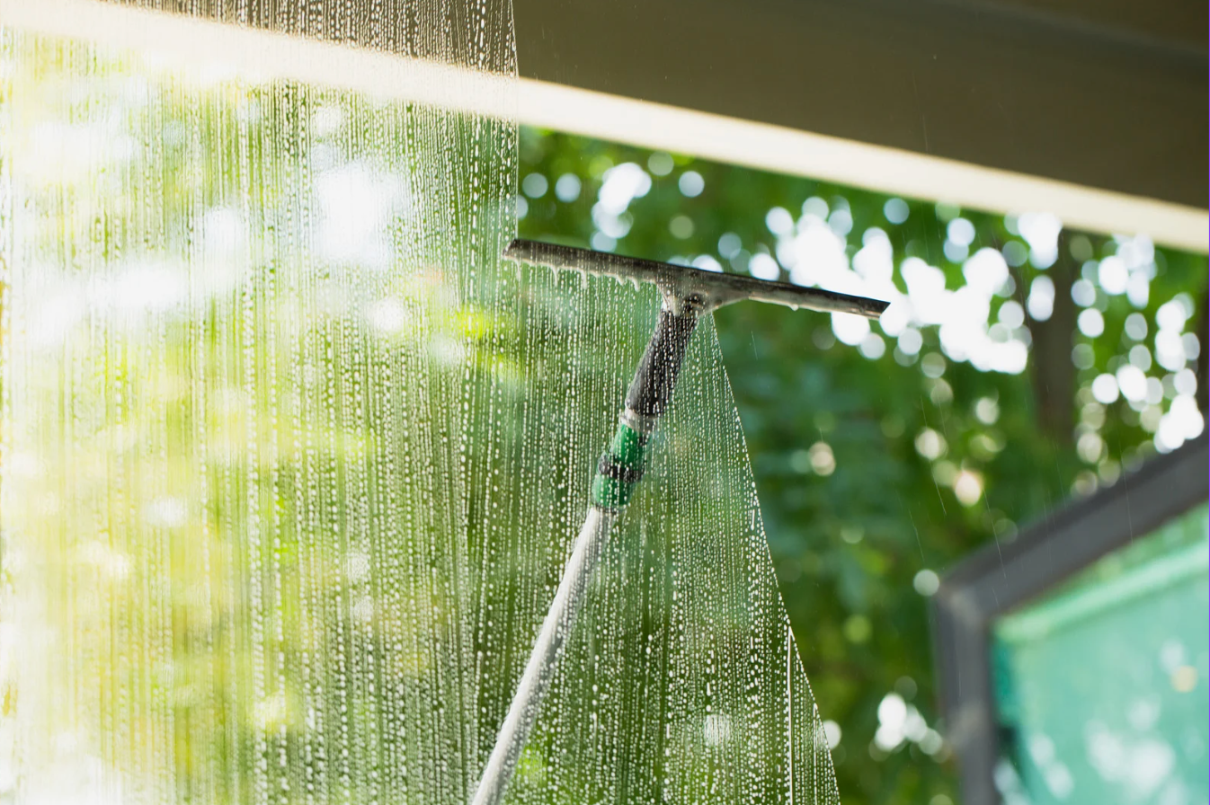 window being cleaned with a long tool