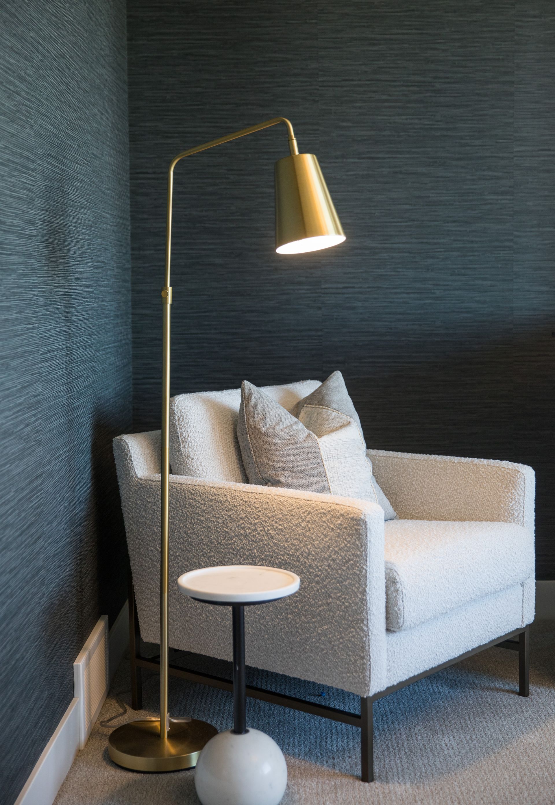 There is a chair and a lamp in the corner of the room.