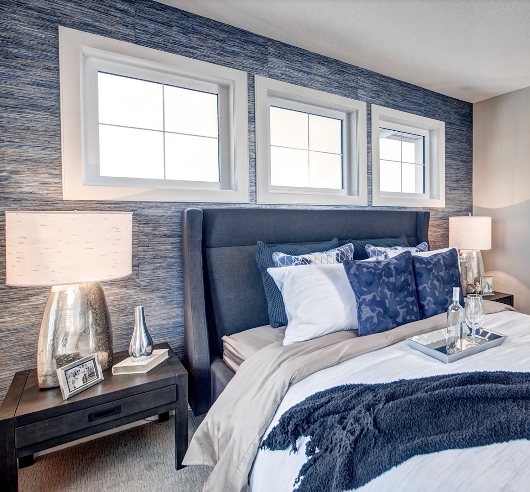 A bedroom with a king size bed and three windows