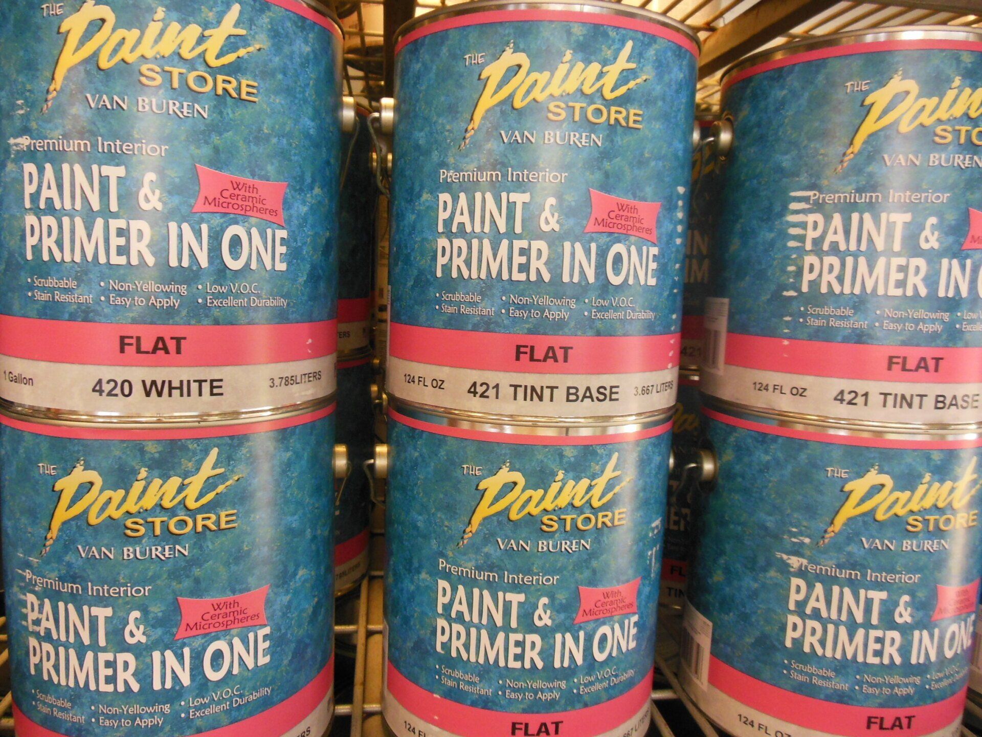 Paint cans stacked on a shelf, labeled 