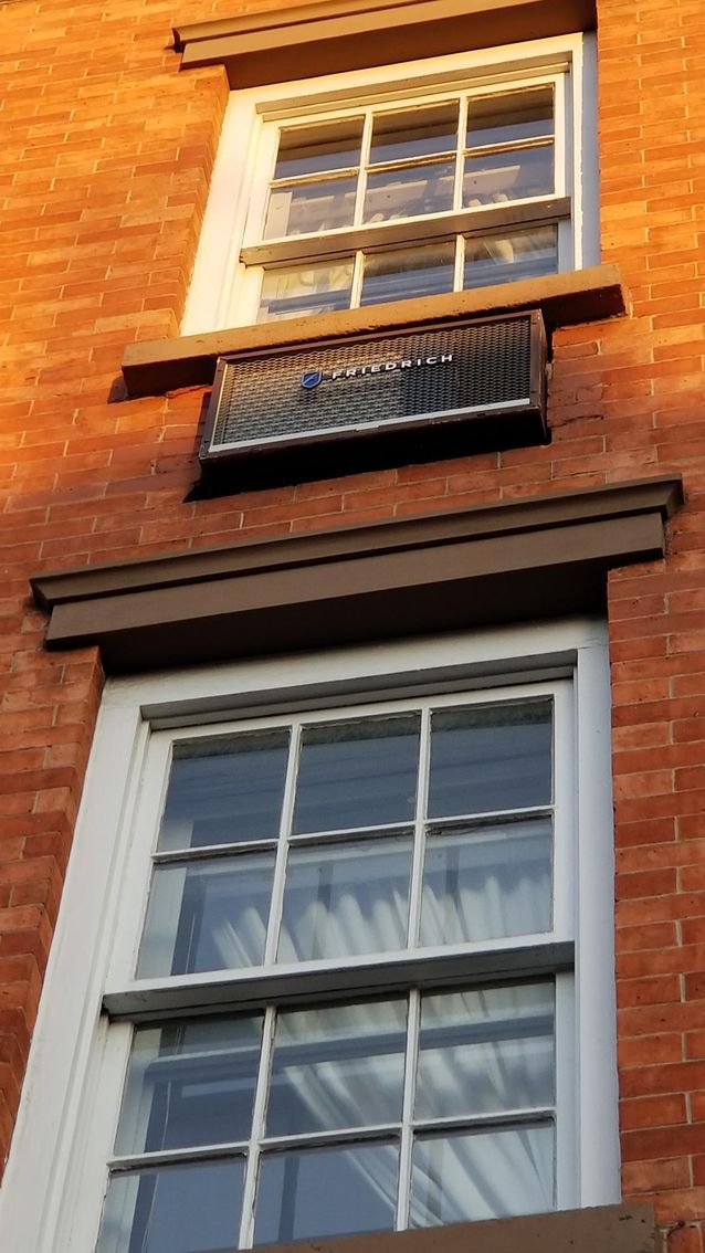 a brick building with three windows and a balcony
