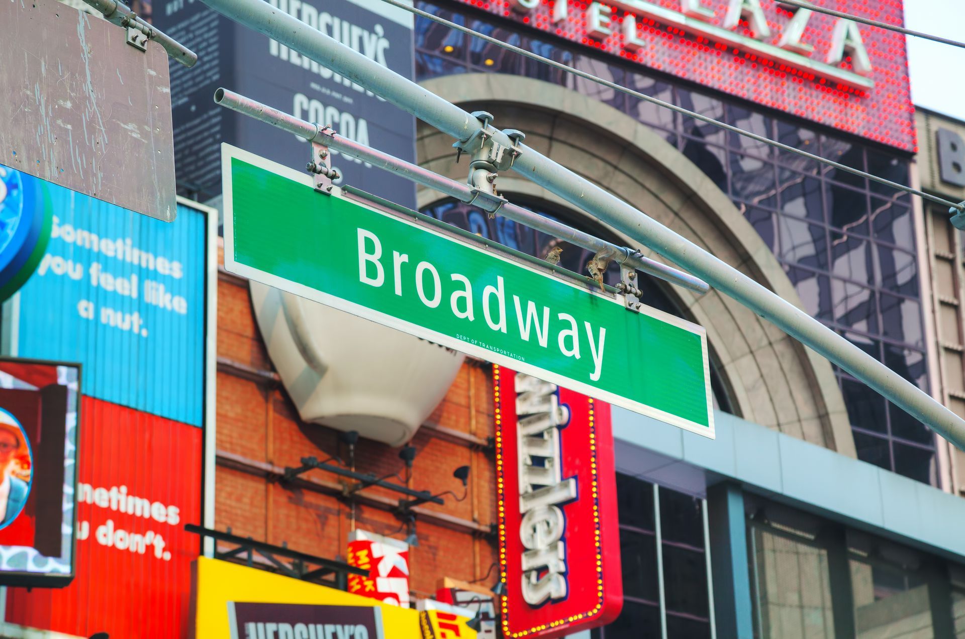 A street sign for broadway is hanging from a pole