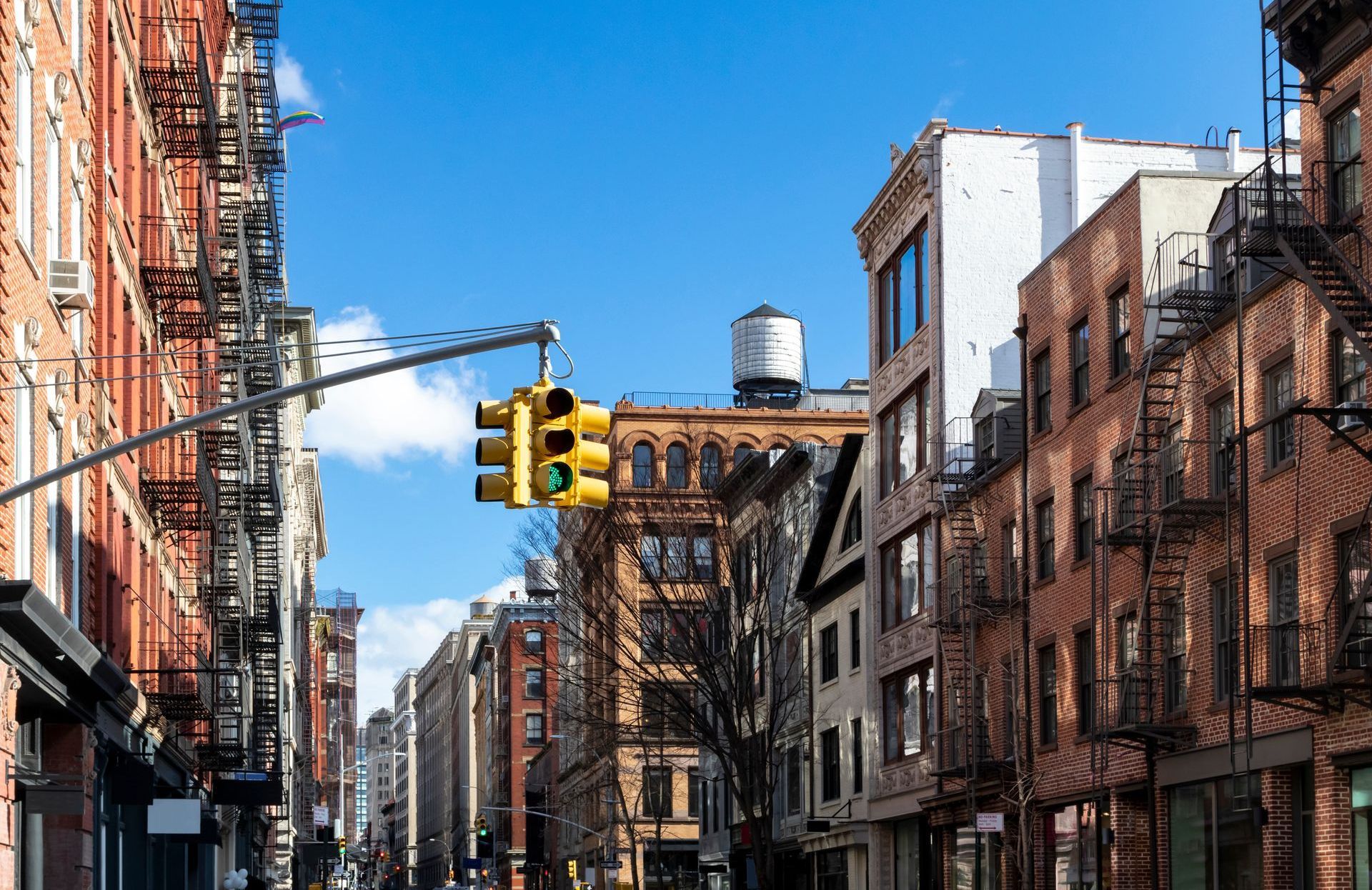 A city street with brick buildings and a traffic light.