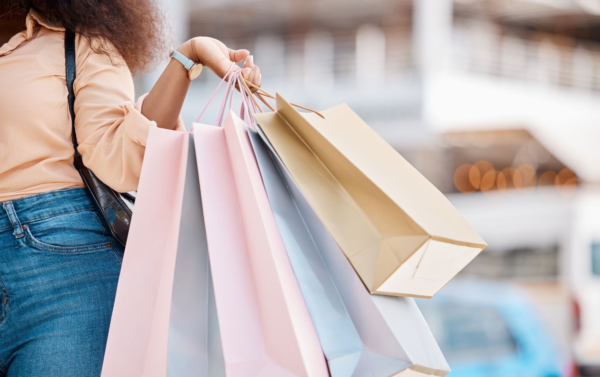 A woman is holding a bunch of shopping bags in her hands.
