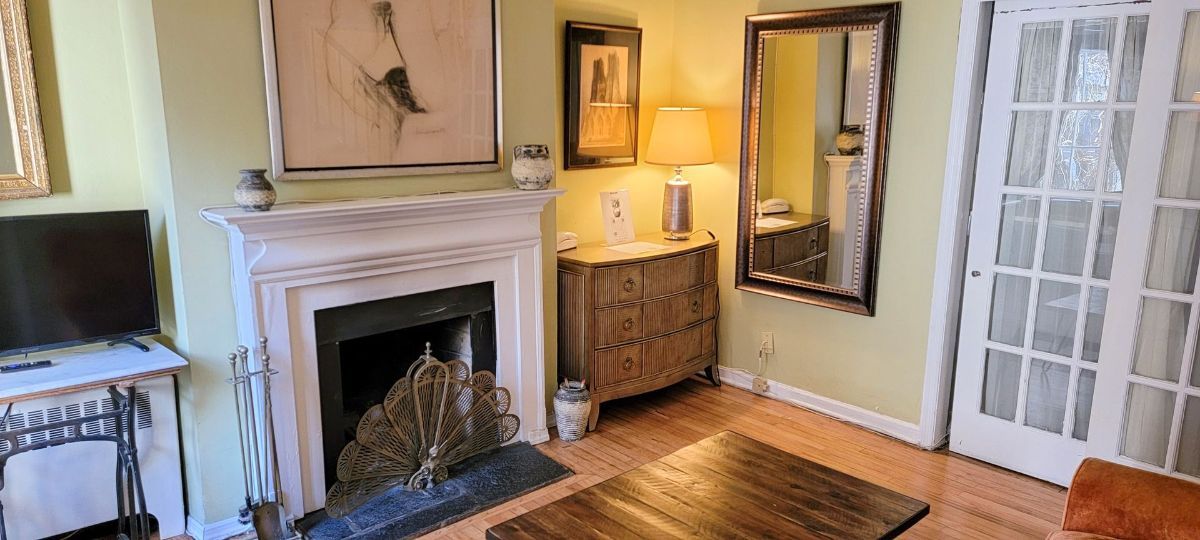 a living room with a fireplace , couch , television and mirrors .