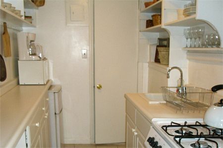 a kitchen with white cabinets and a stove top oven