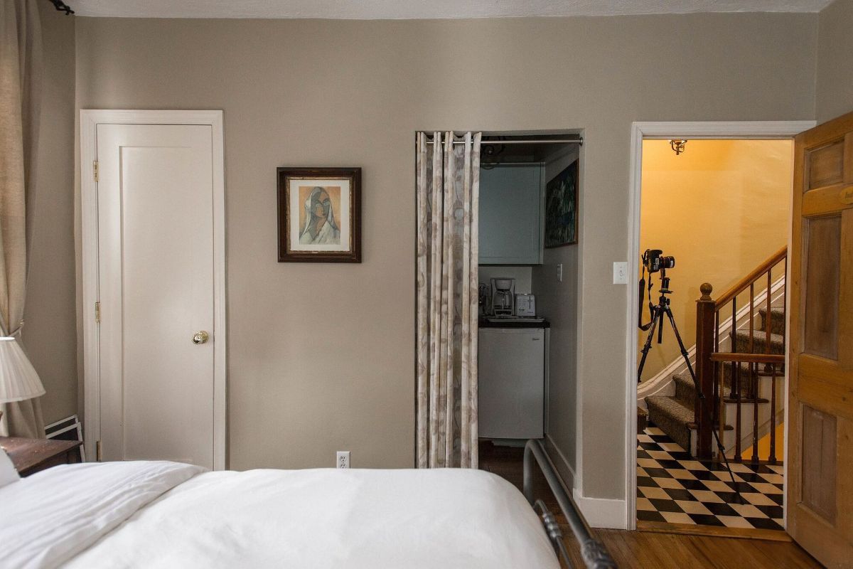 a bedroom with a bed , stairs and a closet .
