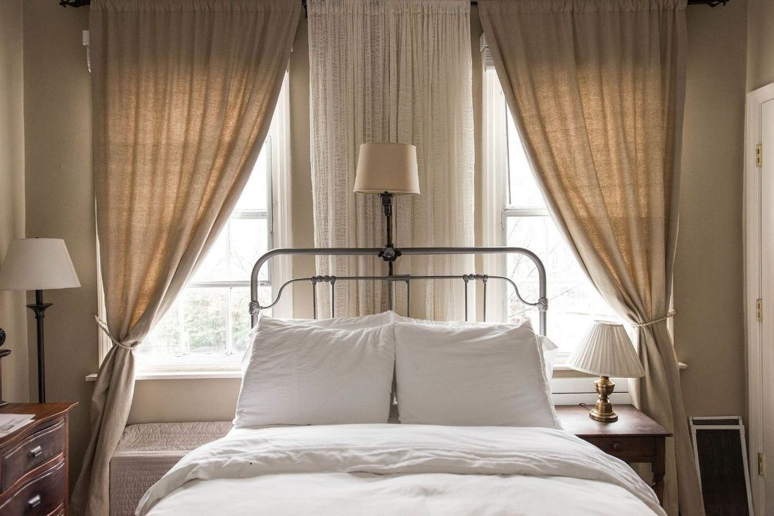 a bedroom with a bed and a window with curtains