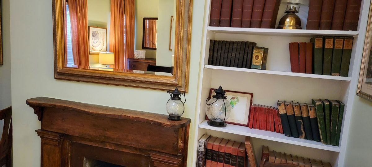 a living room with a fireplace and a bookshelf filled with books .