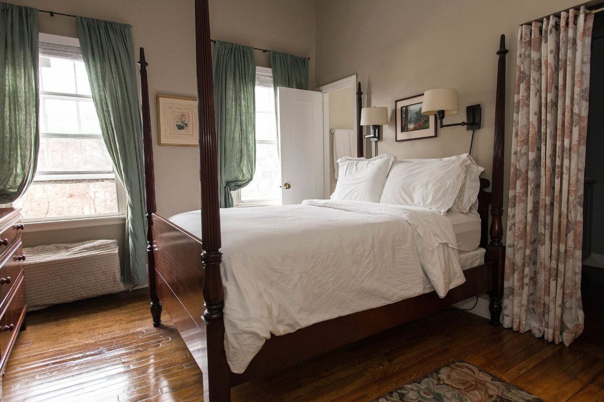 a bedroom with a four post bed and a dresser