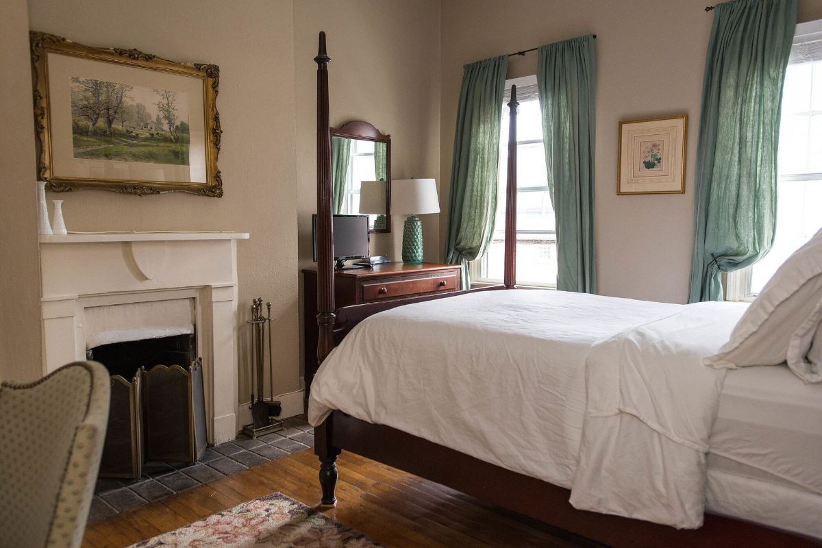 a bedroom with a four poster bed and a fireplace