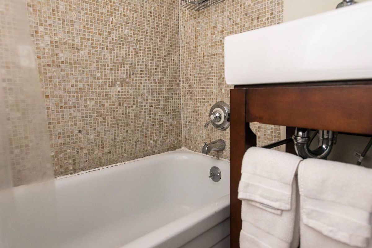 a bathroom with a bathtub , sink and towels