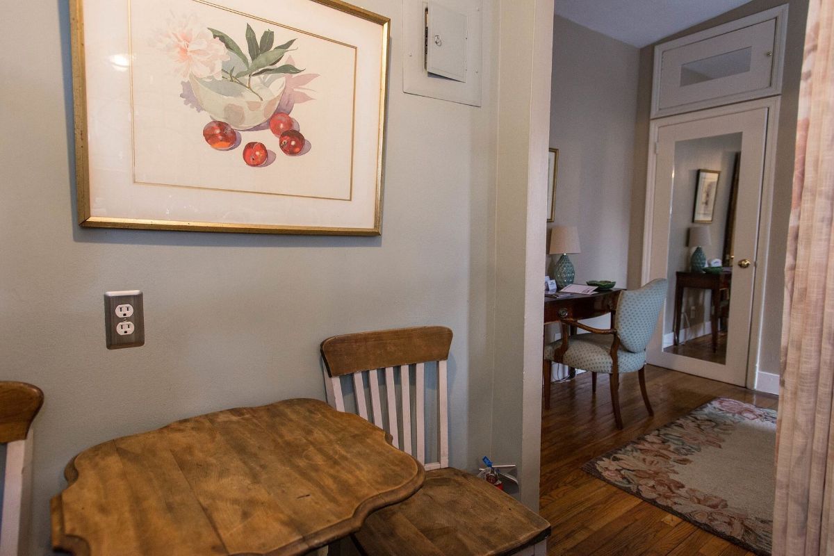 a room with a table and chairs and a picture on the wall .