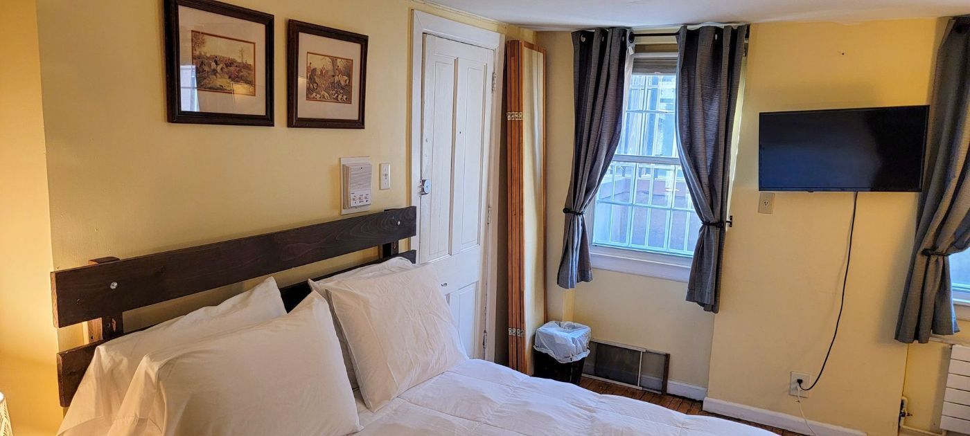 a bedroom with a bed , television , and two pictures on the wall .