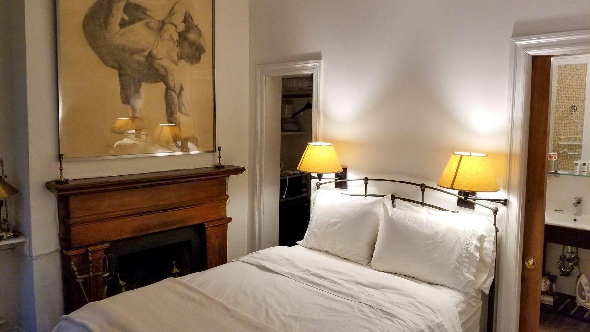 a bedroom with a bed , fireplace and lamps