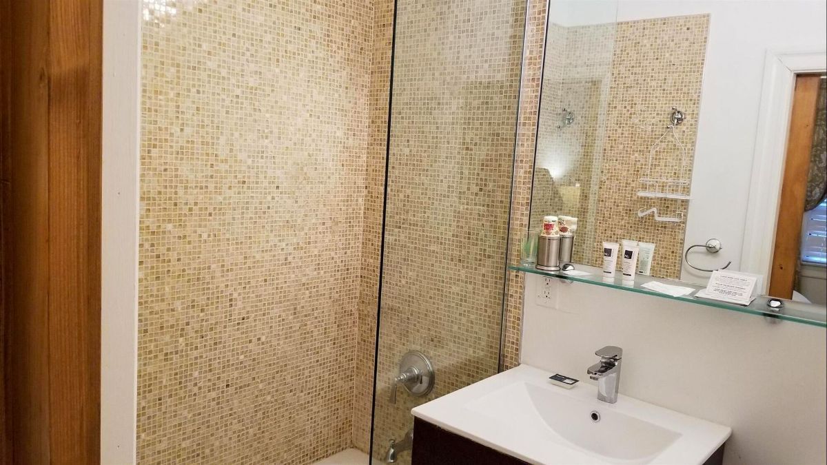a bathroom with a sink and a walk in shower .