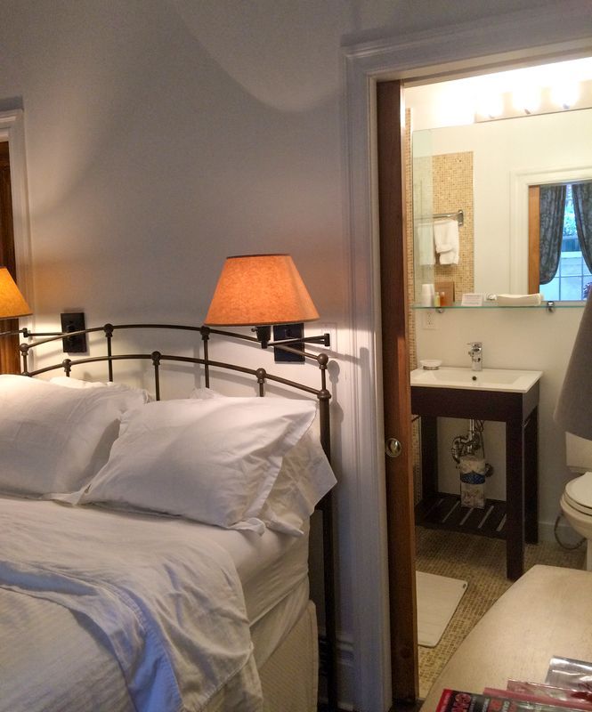 a bedroom with a bed a lamp and a bathroom