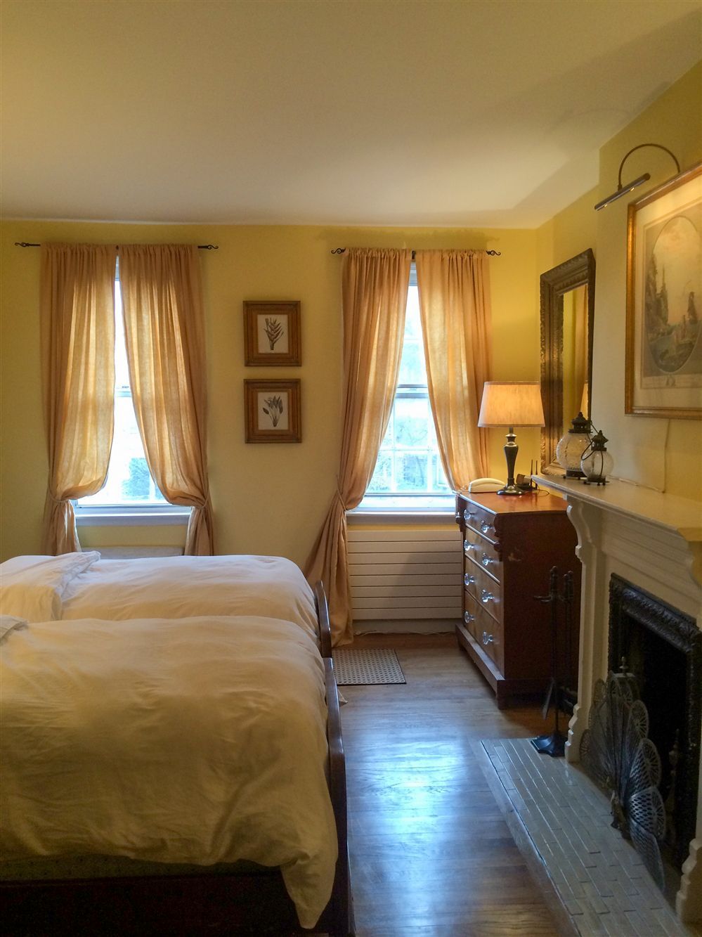 a bedroom with two beds and a fireplace