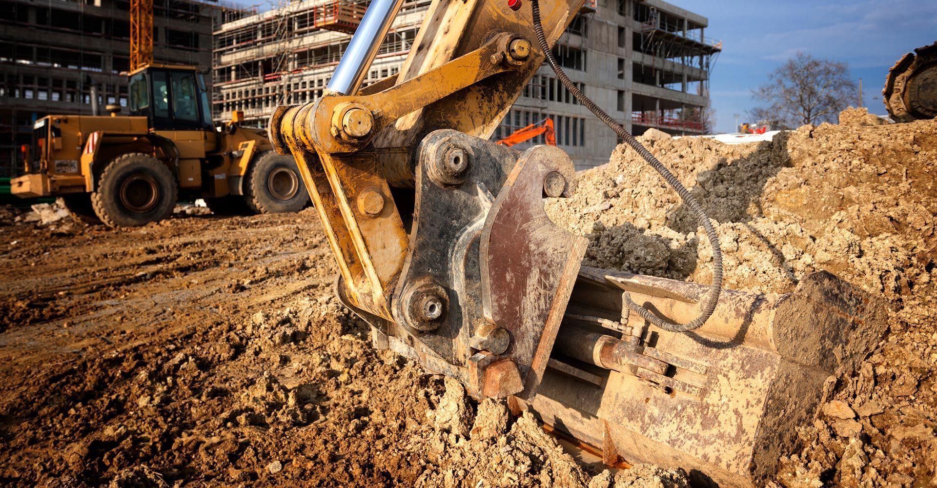 A bulldozer is digging a hole in the dirt at a construction site. A bulldozer is digging a hole in the dirt at a construction site.