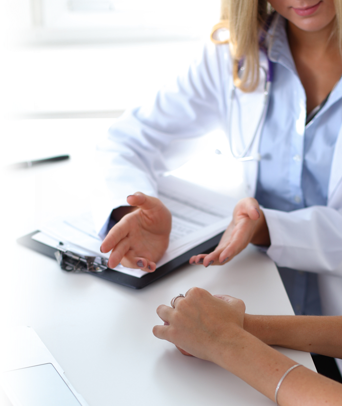 A woman in a lab coat is talking to a patient