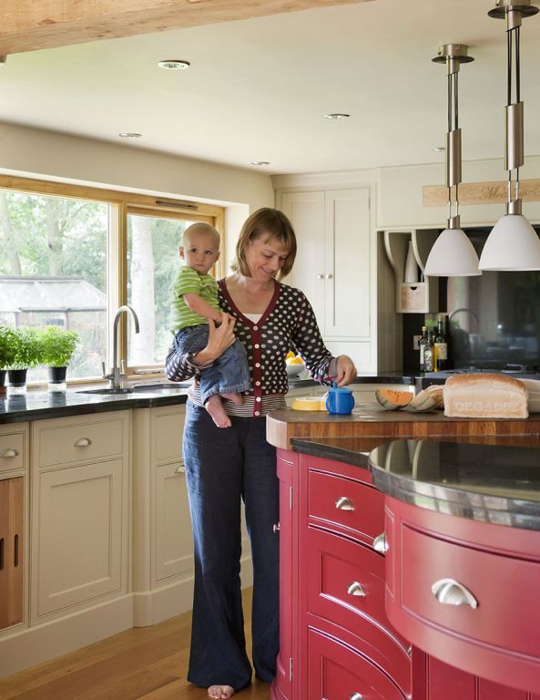 A woman is holding a baby in her arms in a kitchen