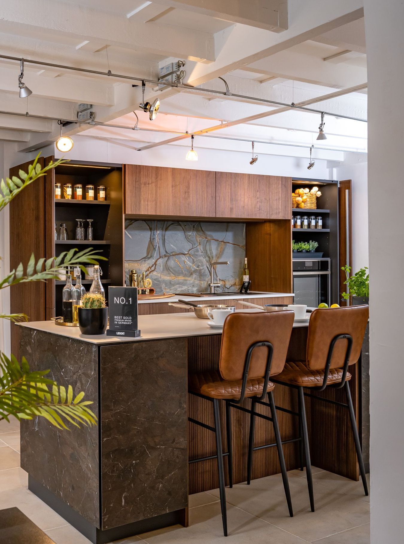A kitchen with a large island and two bar stools