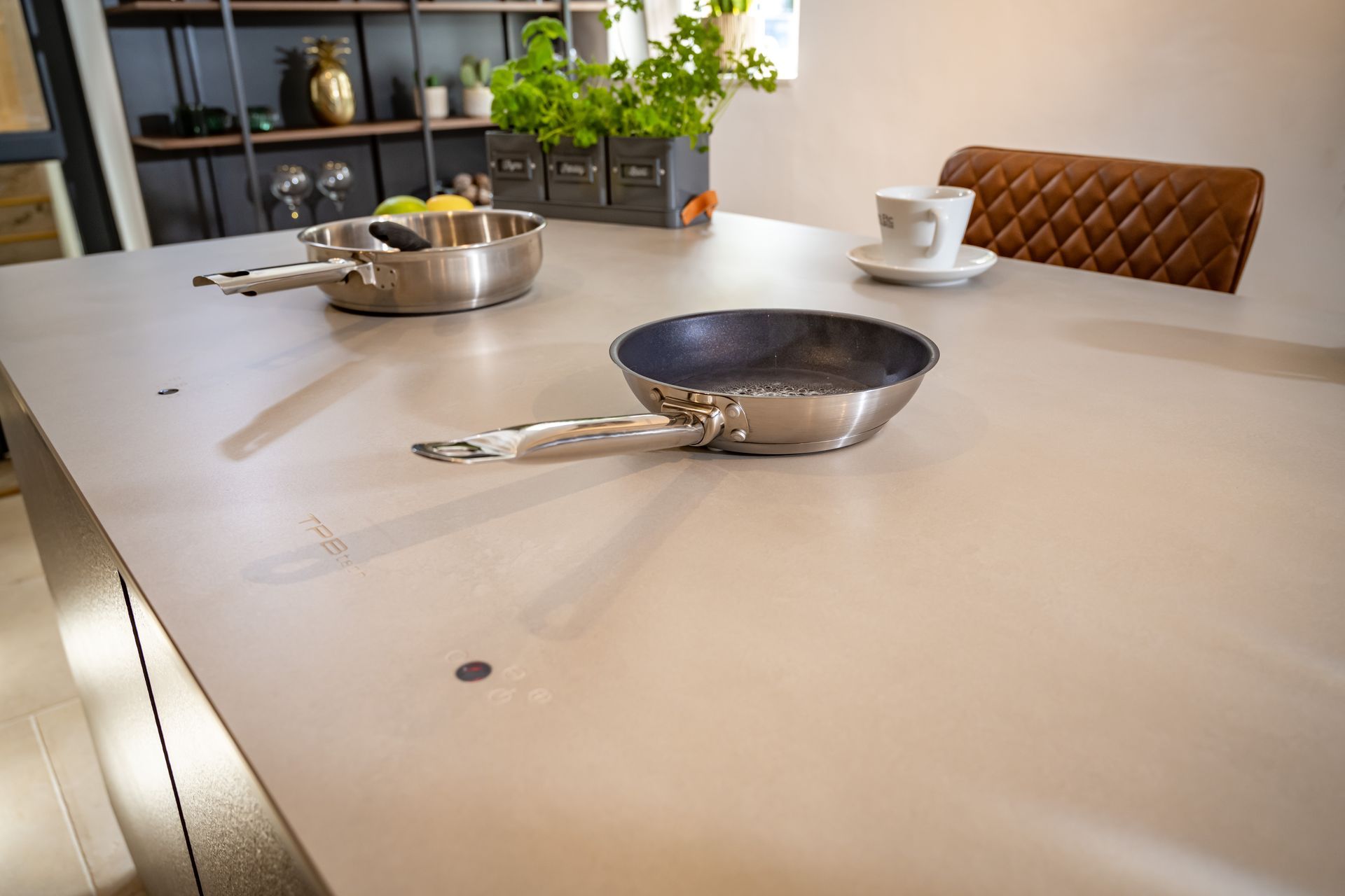 A pan is sitting on a kitchen counter next to a cup of coffee.