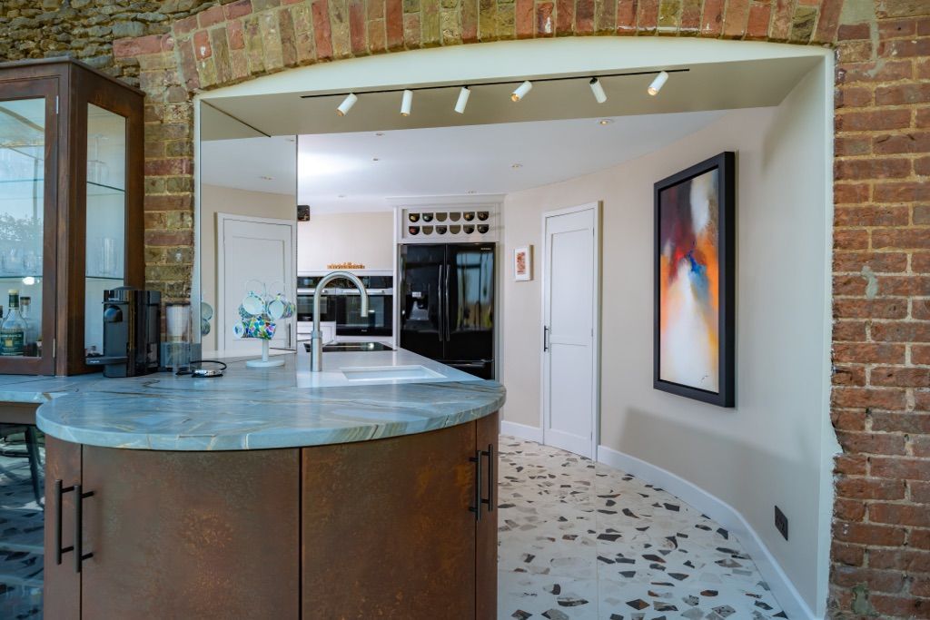 A kitchen with a round counter top and a painting on the wall.