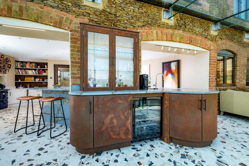 A kitchen with a large island and a brick wall.