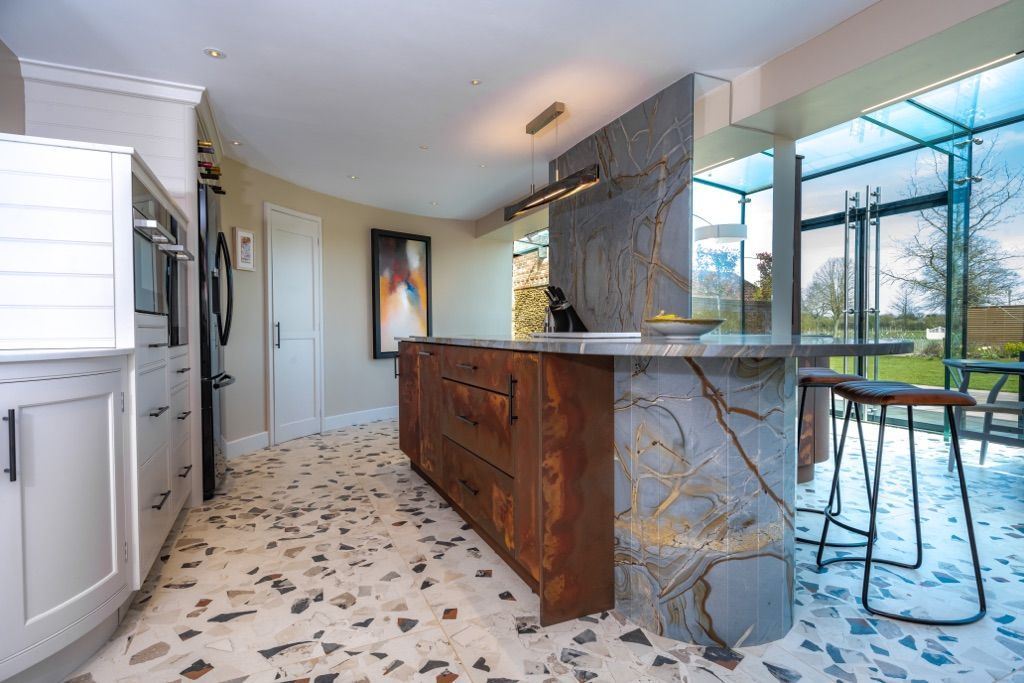 A kitchen with a marble counter top and a terrazzo floor.