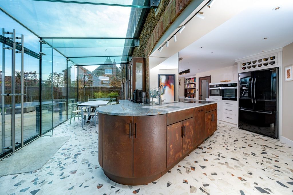 A kitchen with a large island in the middle and a glass ceiling.