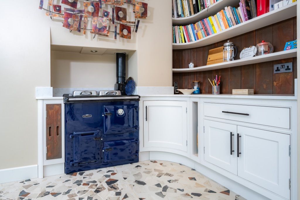 A kitchen with a blue stove and white cabinets.