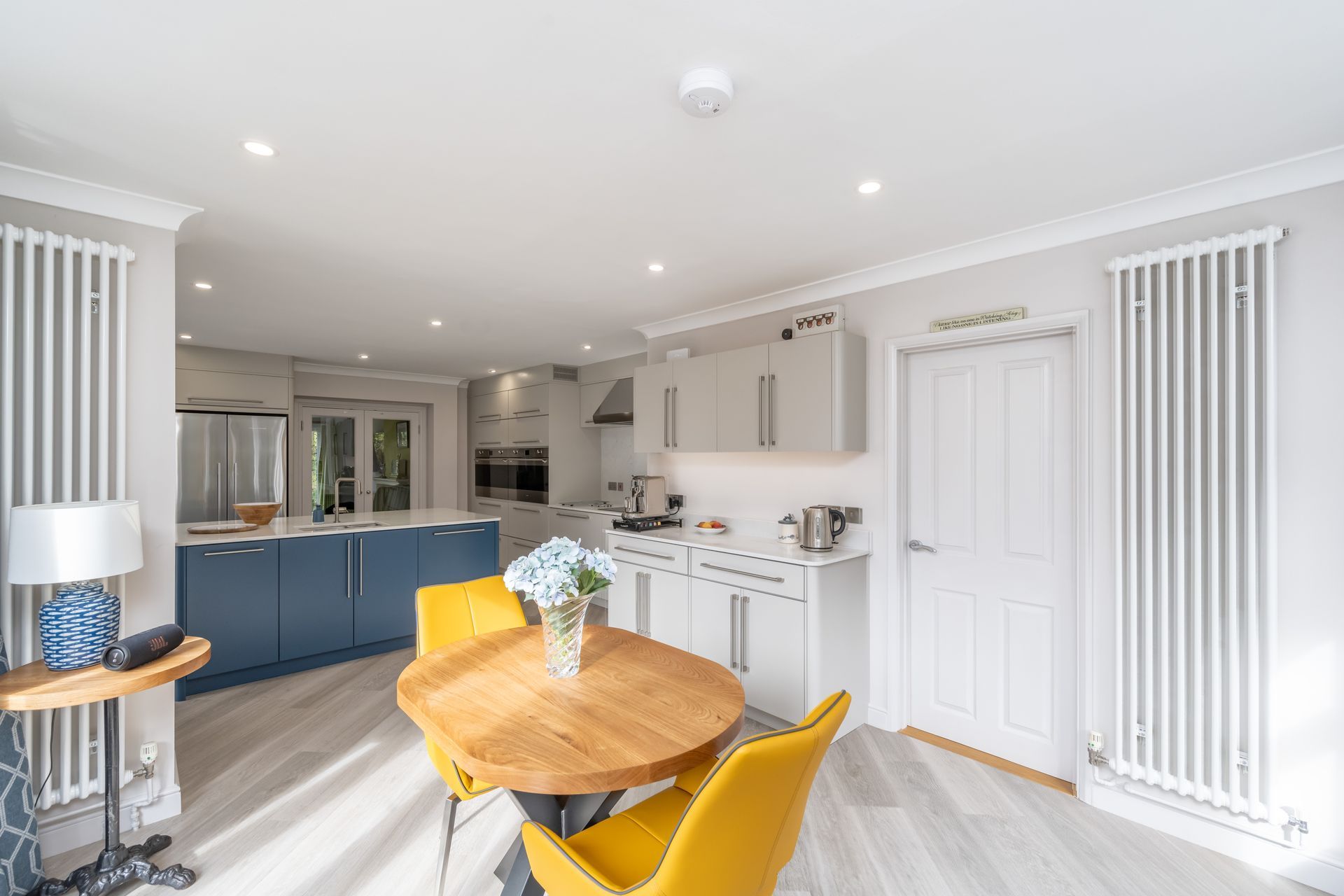 A kitchen with a large island and wicker bar stools.