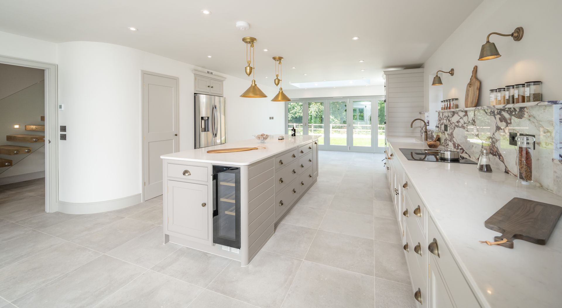 A kitchen with a large island and wicker bar stools.