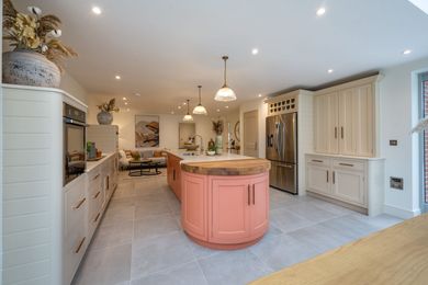 A kitchen with pink cabinets and a large island in the middle.