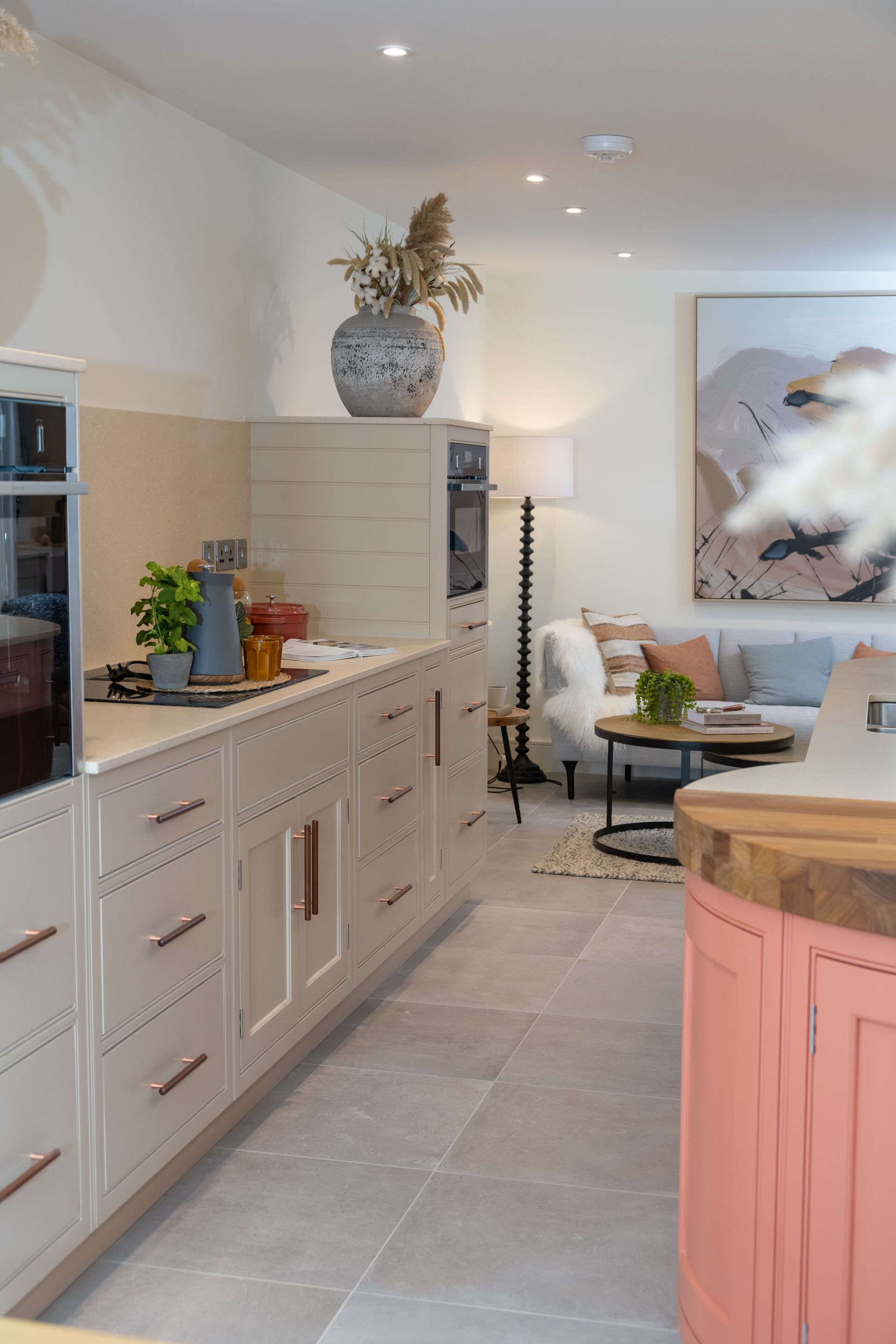 A wooden stool is sitting next to a counter in a kitchen.