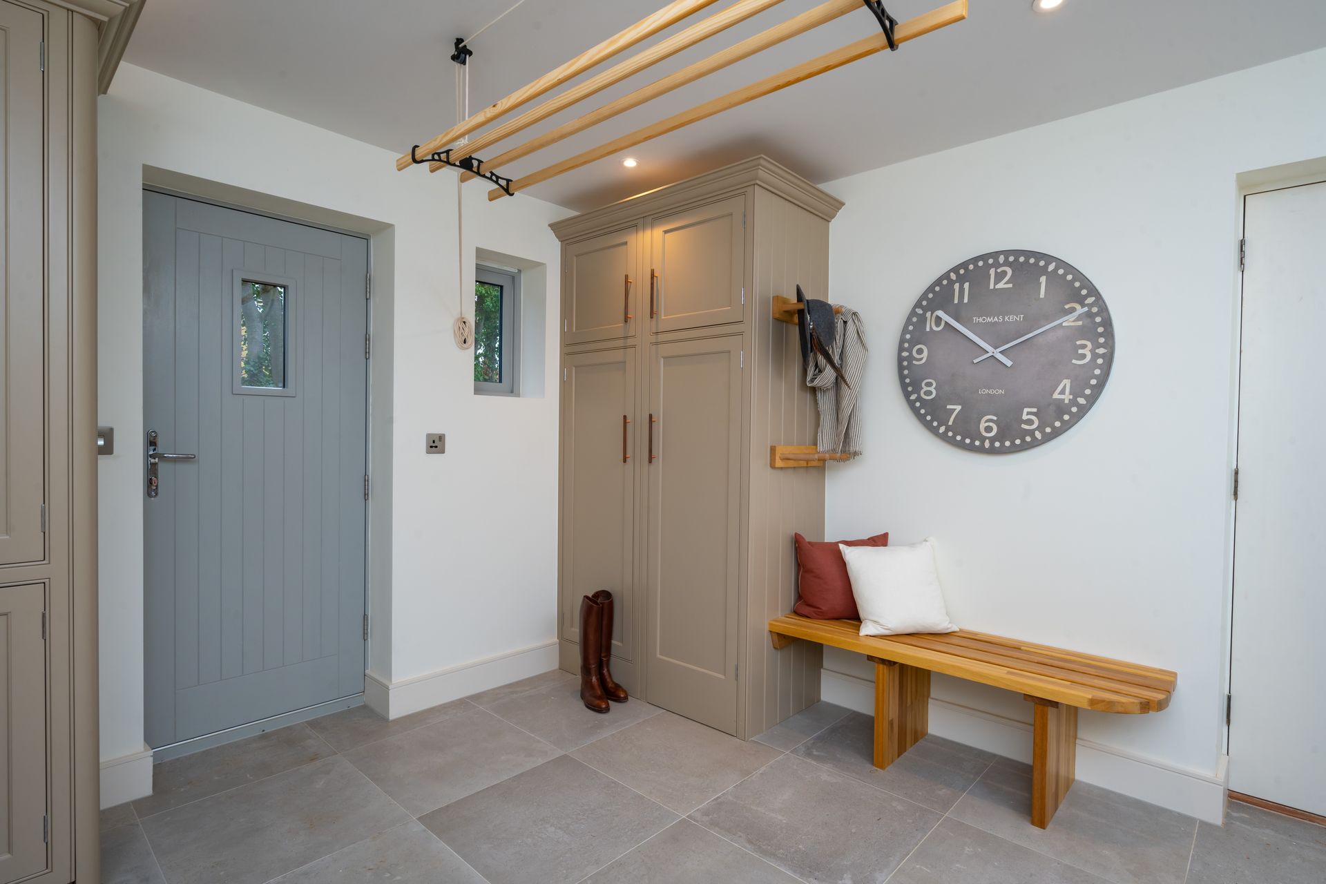 A hallway with a bench and a clock on the wall.