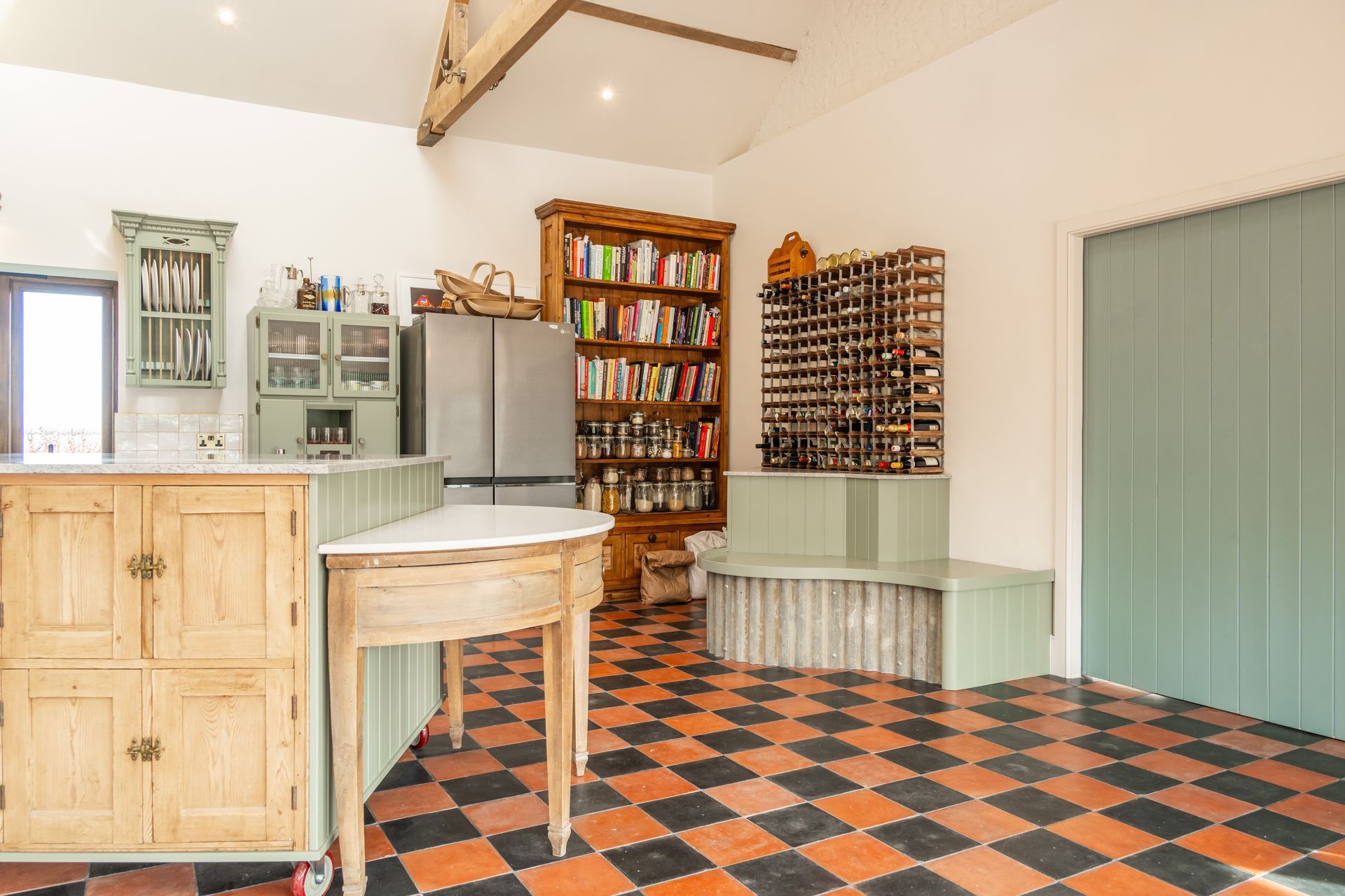 A kitchen with a large island and wicker bar stools.