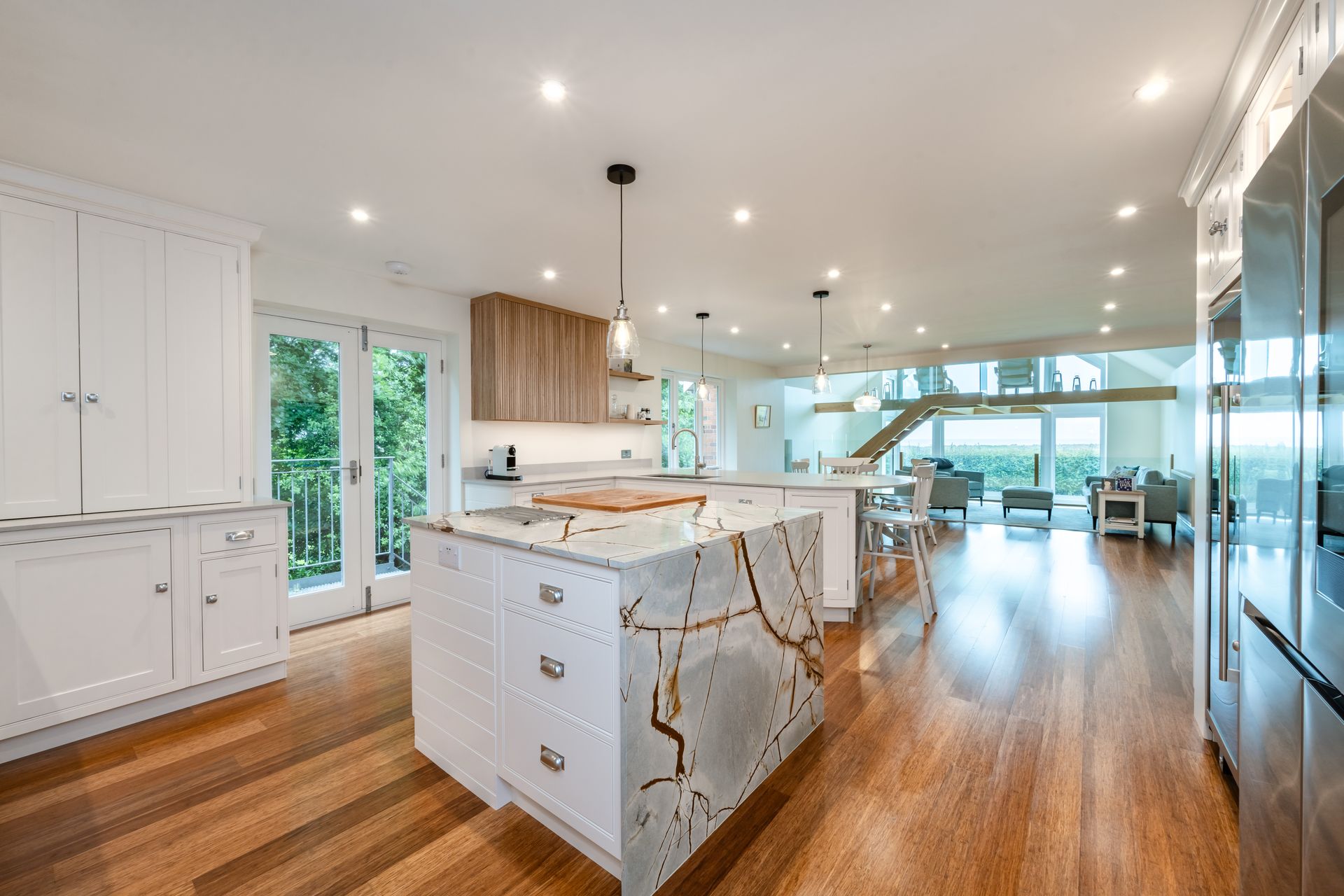 A kitchen with white cabinets and a large island in the middle of the room.