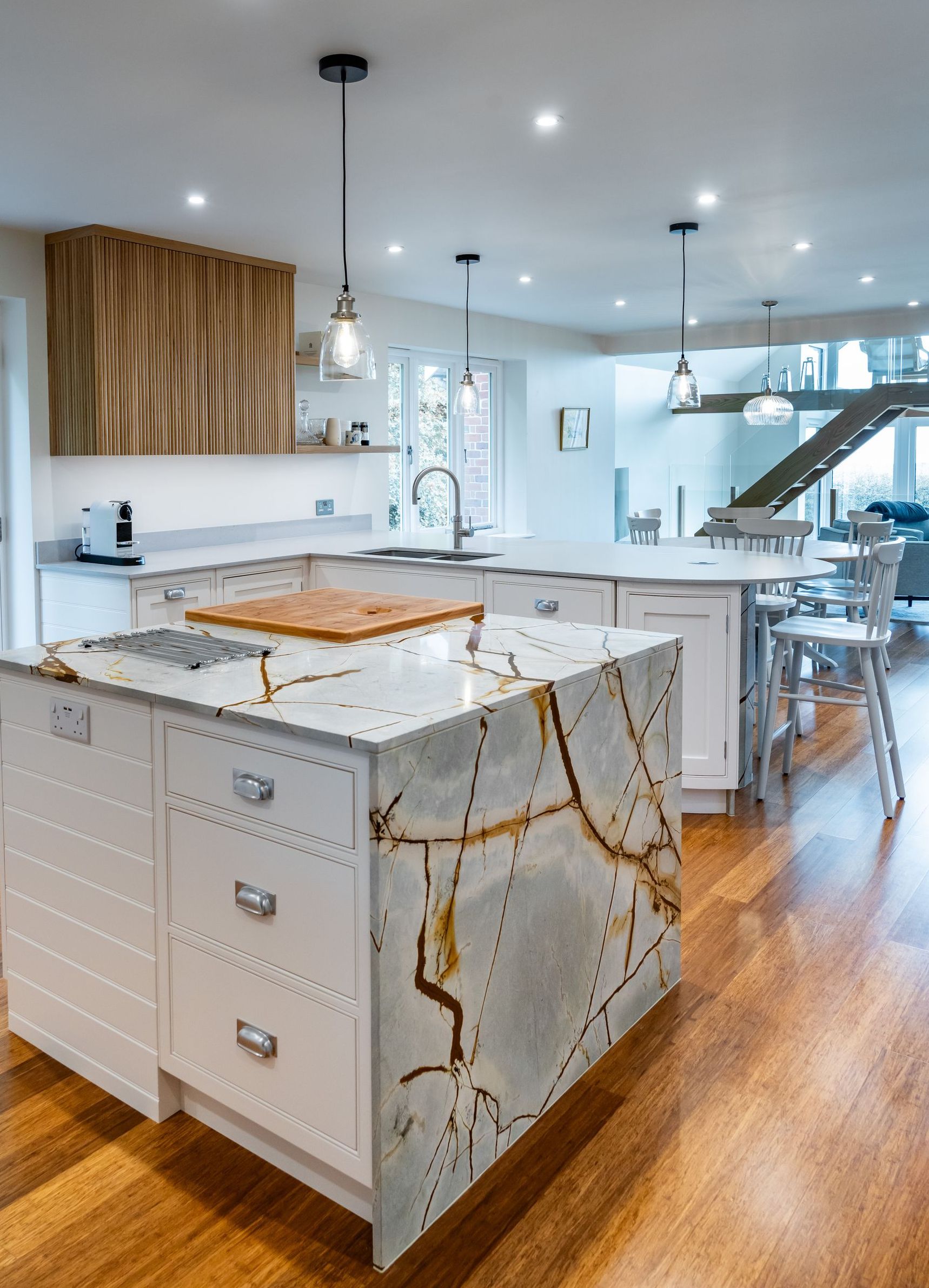 A kitchen with white cabinets , stainless steel appliances , and a large island.