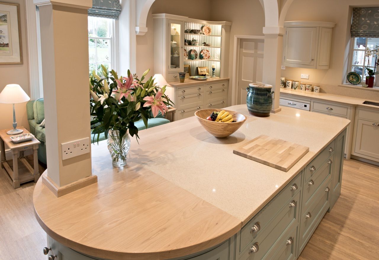 A kitchen with a large island and a bowl of fruit on it