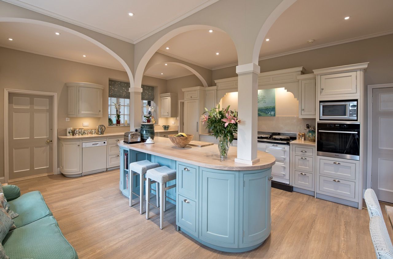 A kitchen with blue cabinets and a large island in the middle of the room.