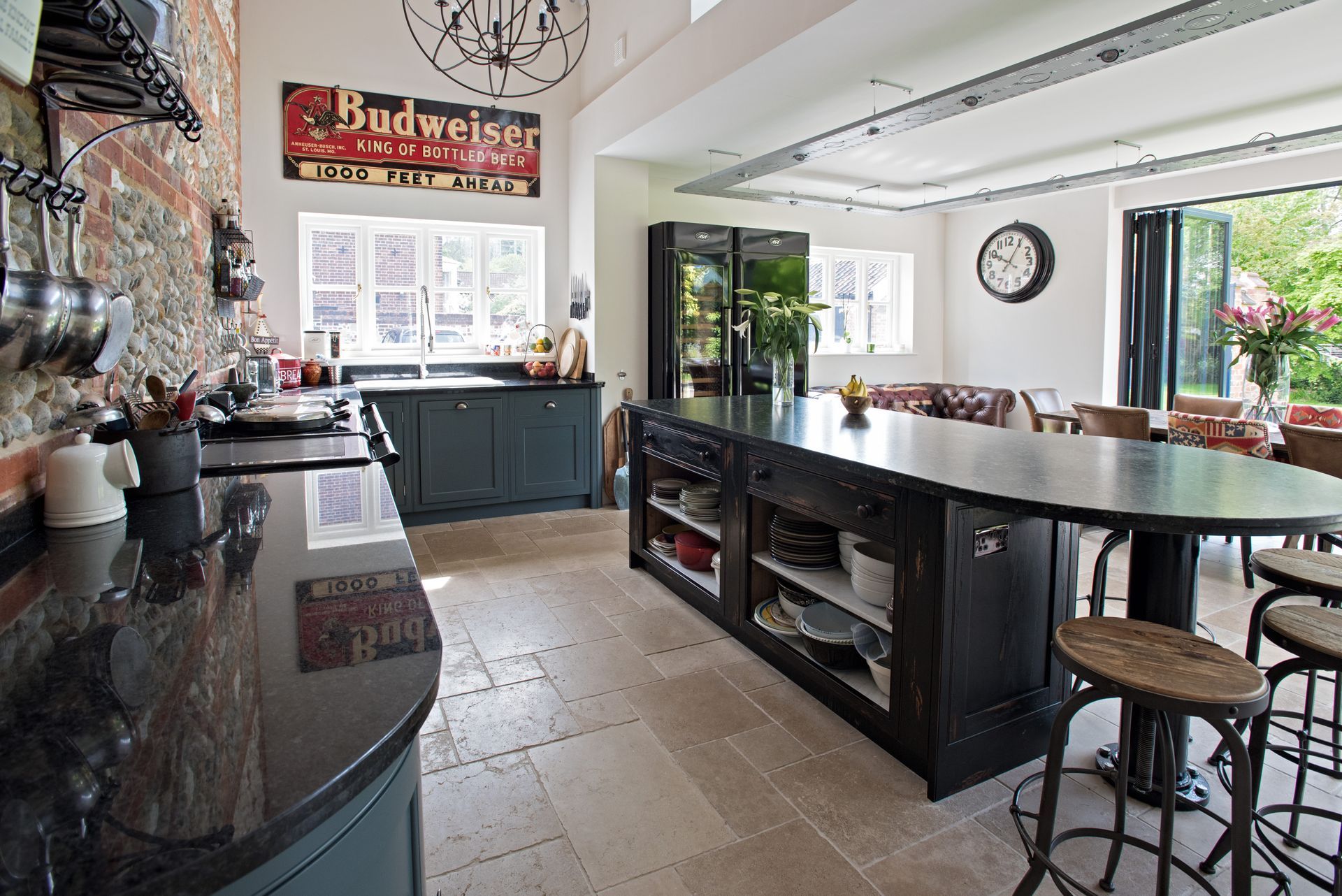 A large kitchen with a budweiser sign on the ceiling.