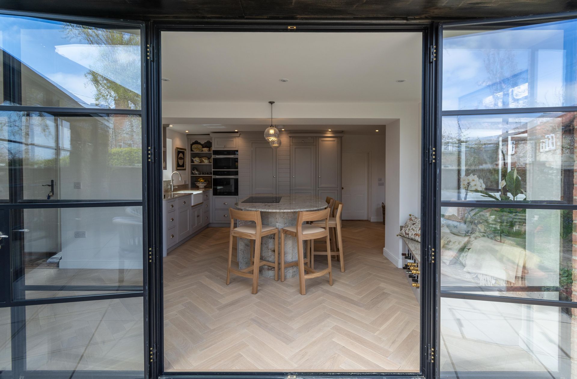 A kitchen with a large island and wicker bar stools.