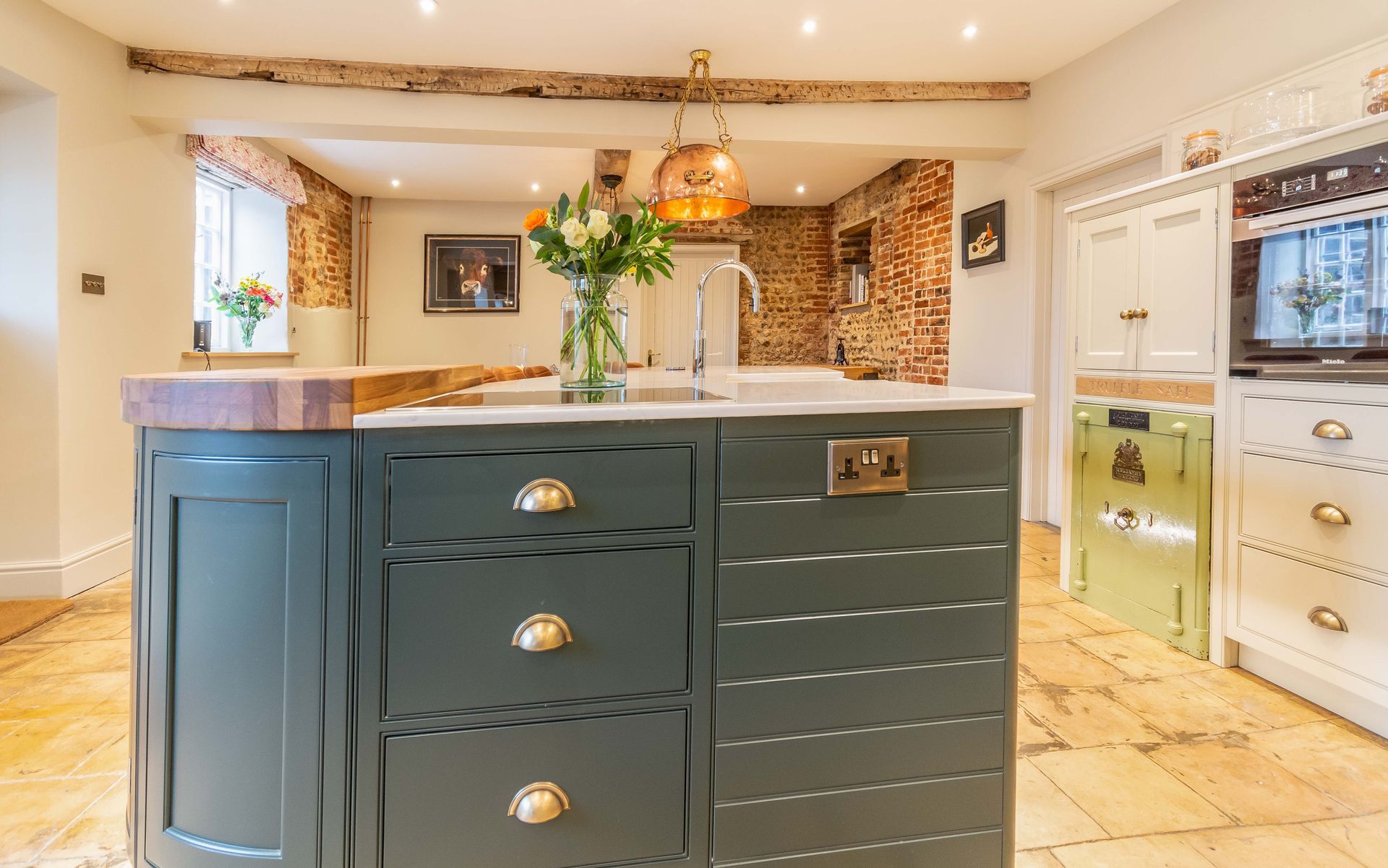 A kitchen with a large island and wicker bar stools.