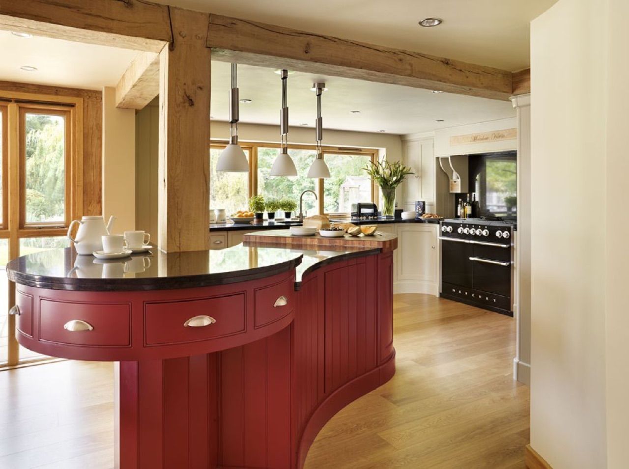 A kitchen with red cabinets and black counter tops