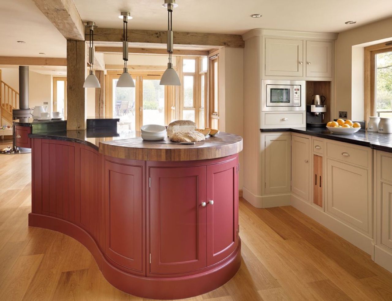 A kitchen with red cabinets and a wooden counter top