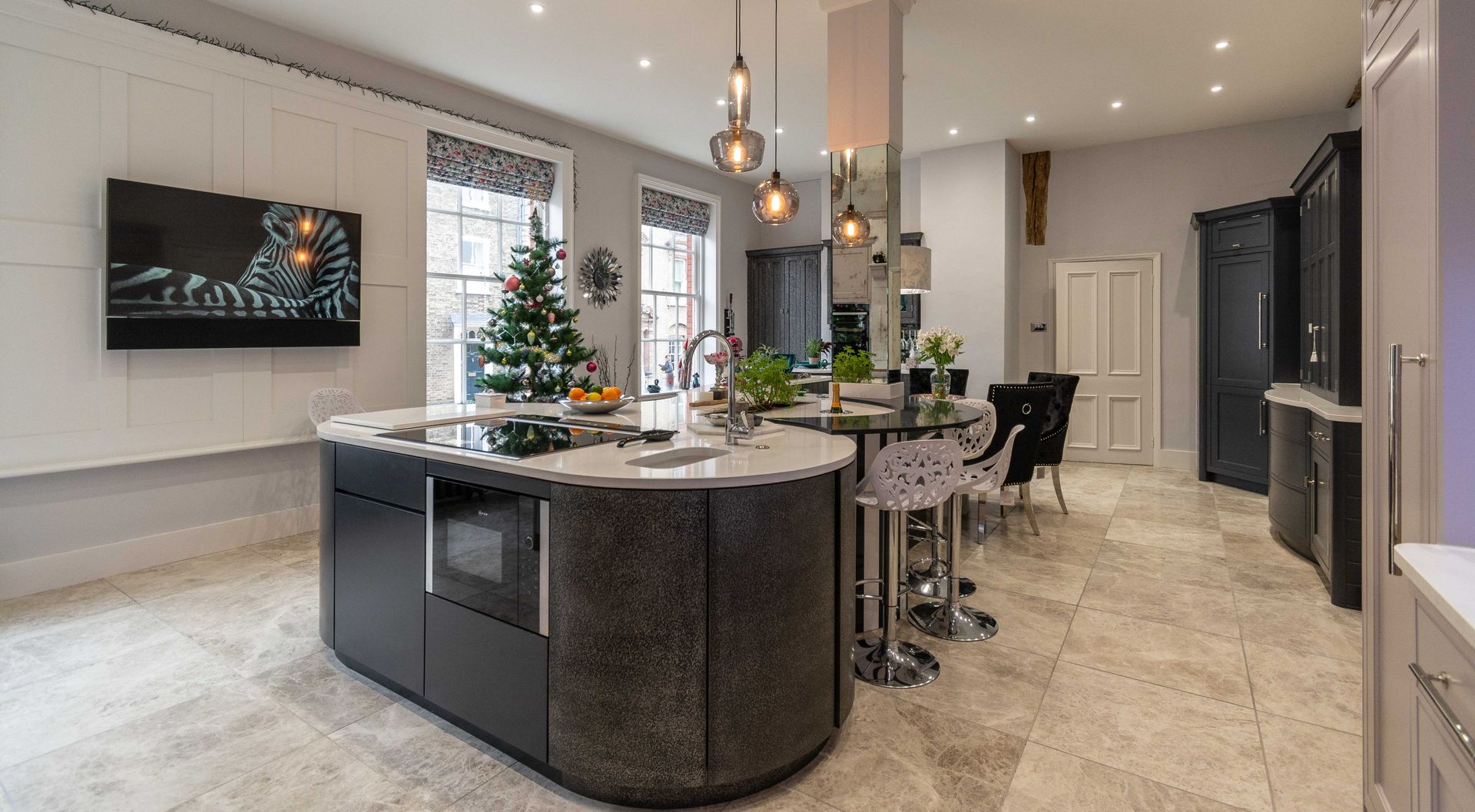 A kitchen with a large island and wicker bar stools.
