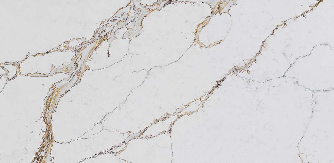 A close up of a white and gold marble counter top.