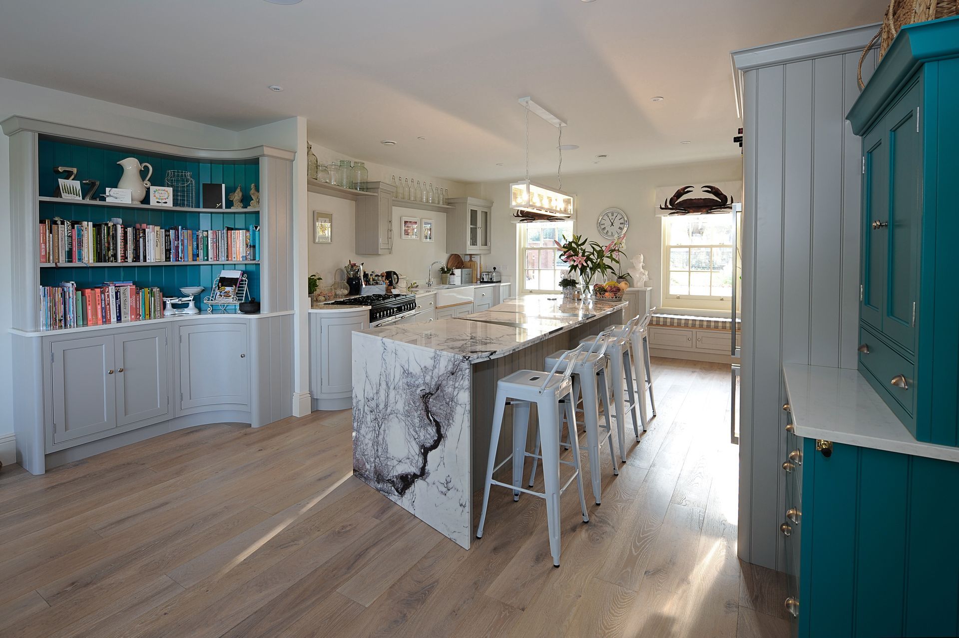 A kitchen with a large island and wicker bar stools.